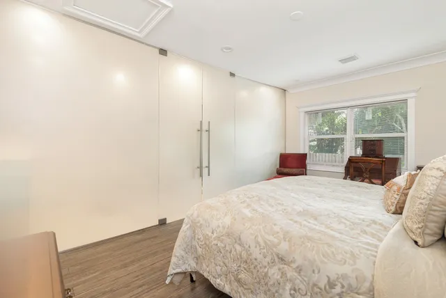 a bedroom with a bed and a large window with balcony view
