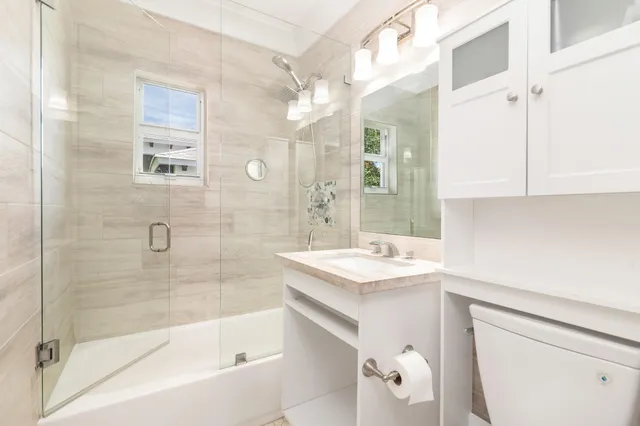 a bathroom with a sink a toilet and shower