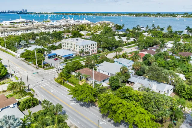 an aerial view of a city with lots of residential buildings ocean and mountain view in back
