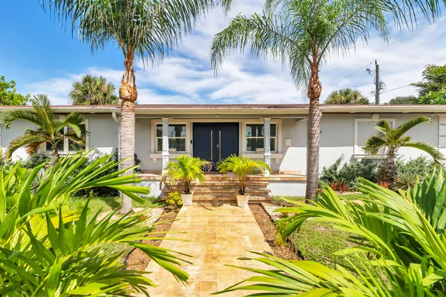 a view of a house with pool and sitting area
