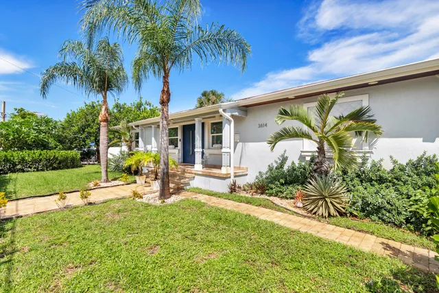 a view of a house with backyard and sitting area