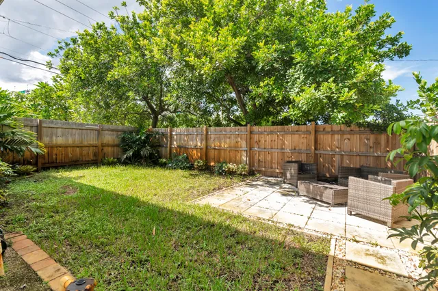 a view of a backyard with a potted plant and a large tree