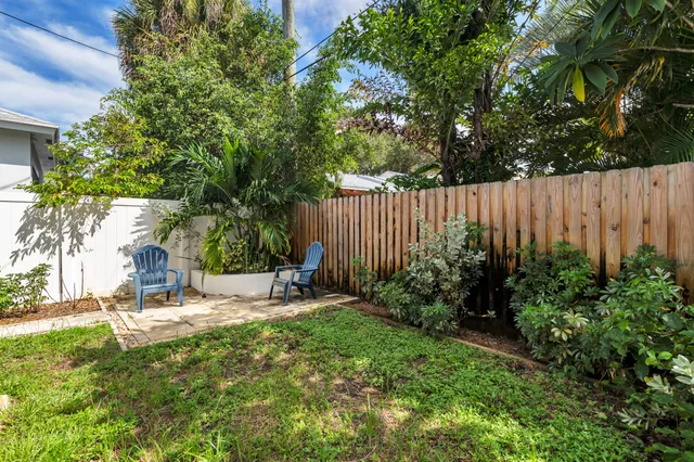 a view of backyard with a table and chairs and a large tree