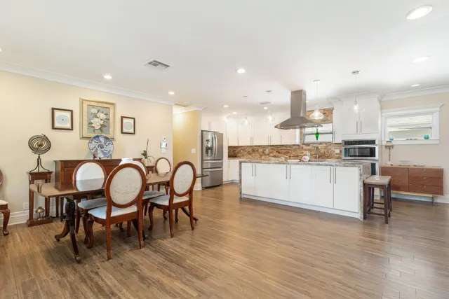a living room with stainless steel appliances kitchen island granite countertop furniture and wooden floor