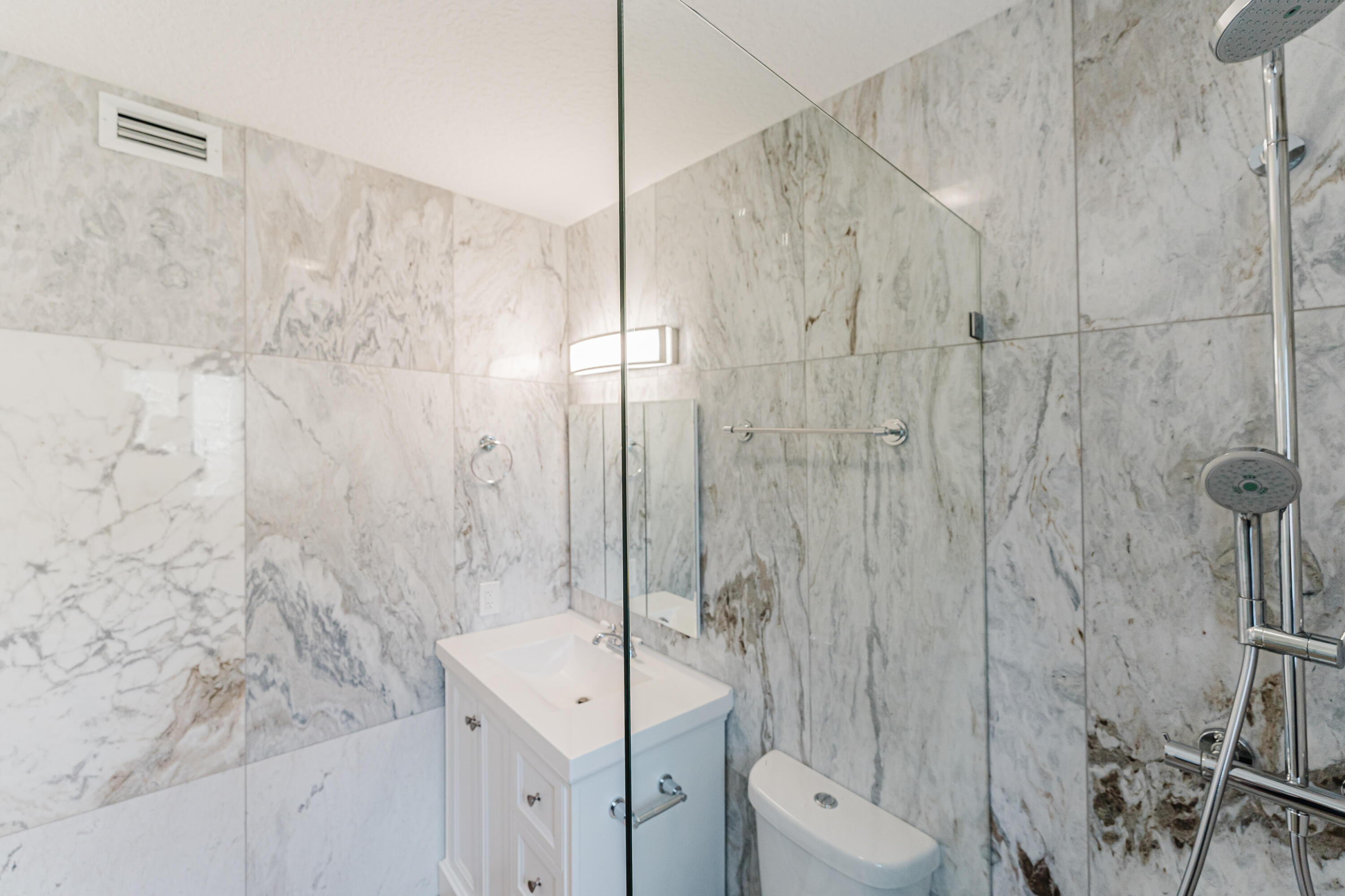 921 Ortega Road West Palm Beach, FL 33405 - Photo 16 of 60 a bathroom with a toilet a sink a shower and mirror