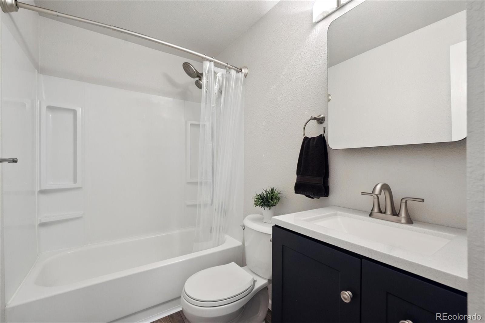704 Madison Way Bennett, CO 80102 - Photo 13 of 29 a bathroom with a sink a toilet and bathtub