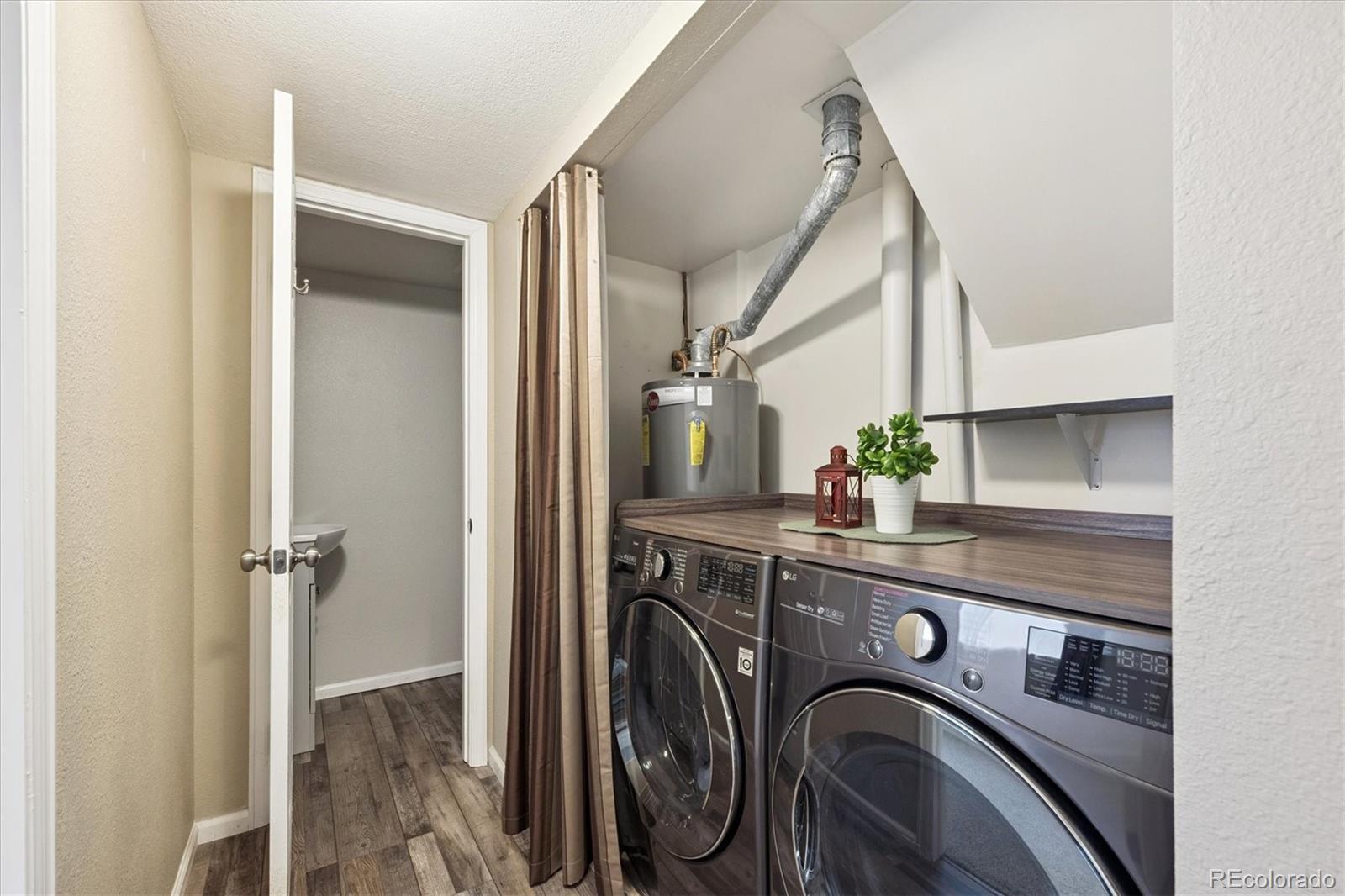 704 Madison Way Bennett, CO 80102 - Photo 17 of 29 a view of a storage and utility room with washer and dryer