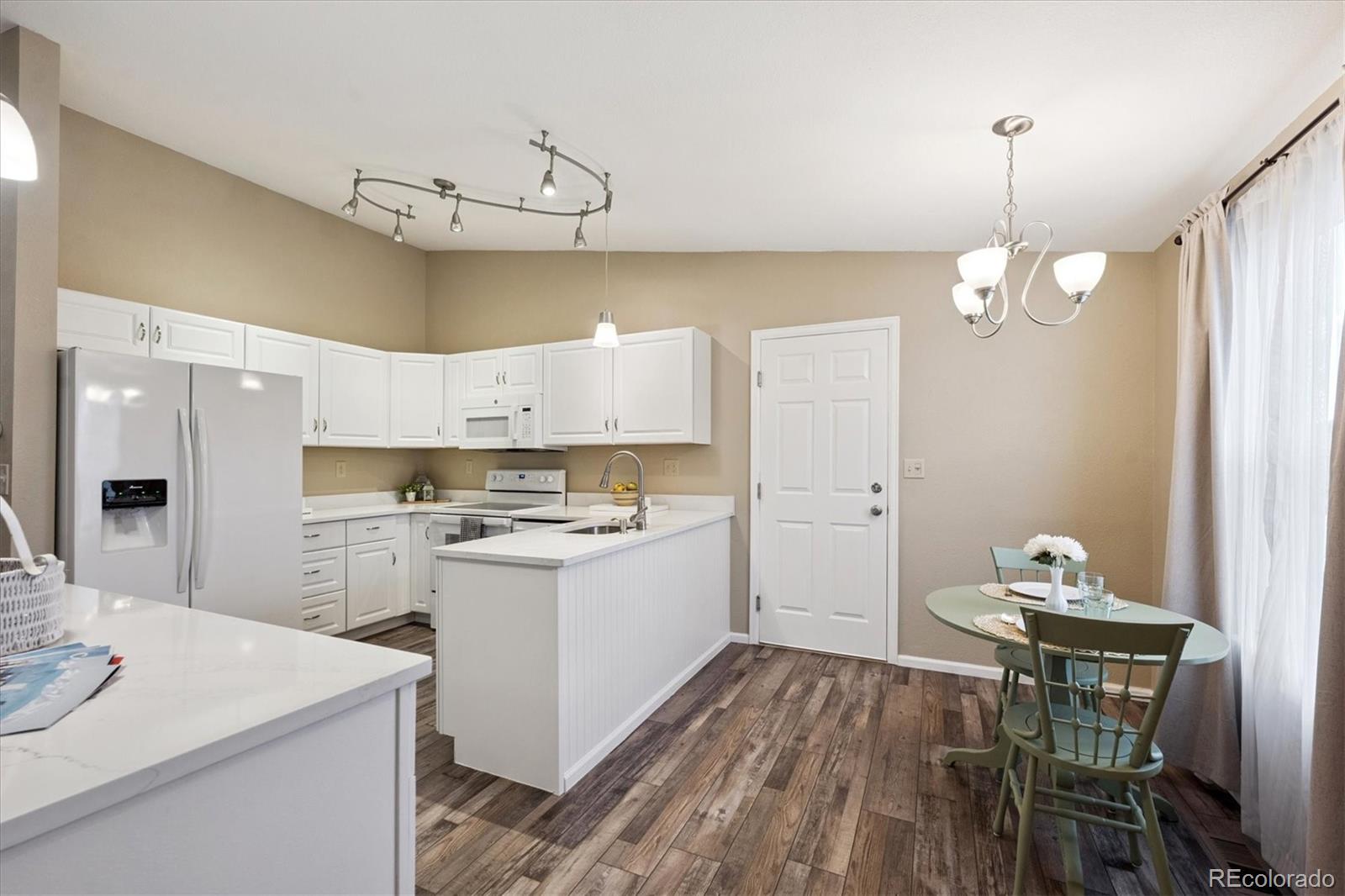 704 Madison Way Bennett, CO 80102 - Photo 9 of 29 a kitchen that has a table and chairs in it