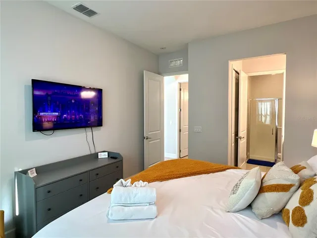 a bedroom with a bed and a flat screen tv