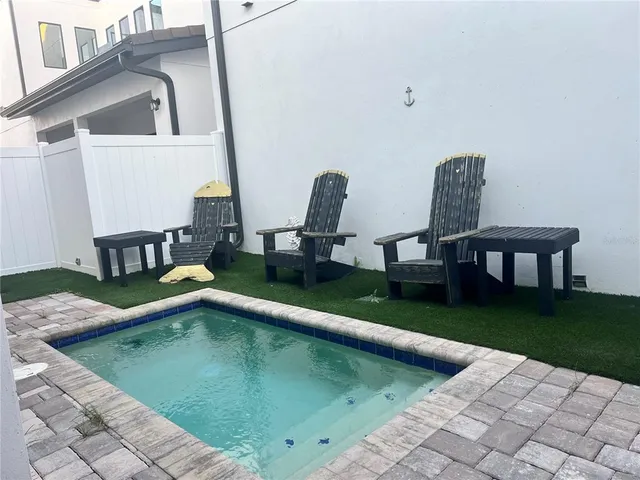 a view of house with swimming pool outdoor seating