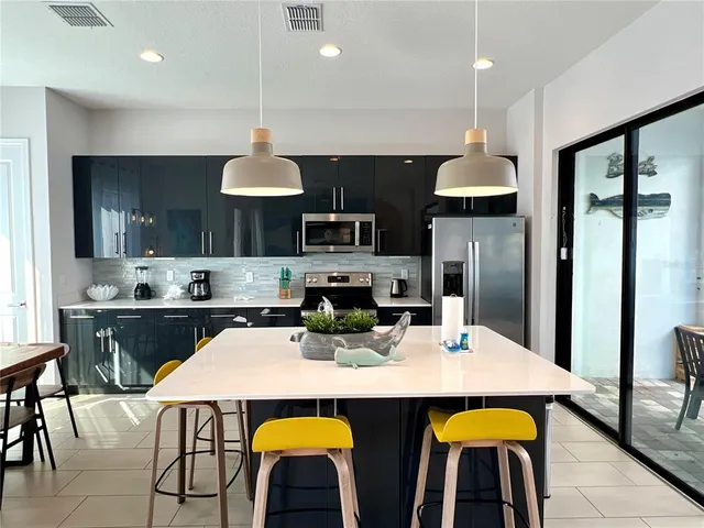 a kitchen with stainless steel appliances a dining table and chairs