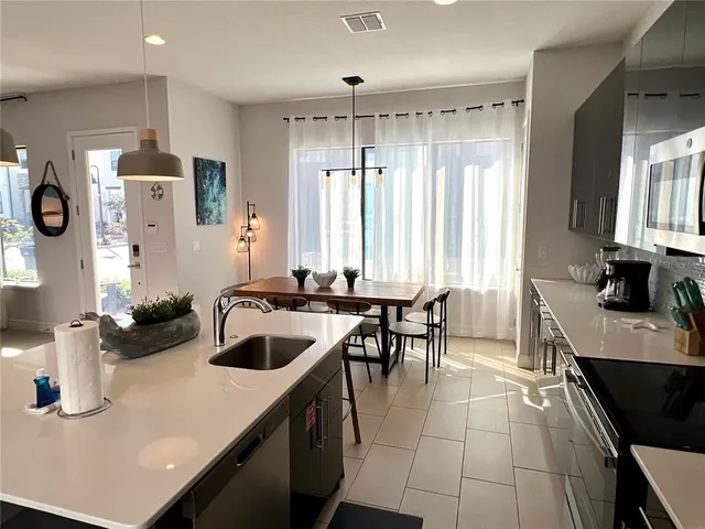 a kitchen with a sink a stove and chairs