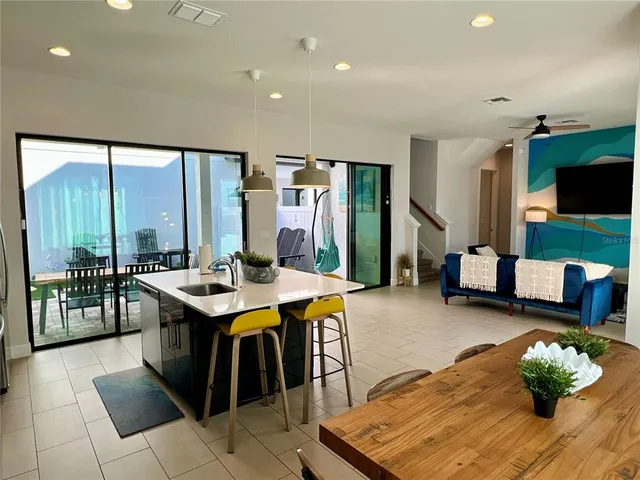 a kitchen with a table chairs and flat screen tv