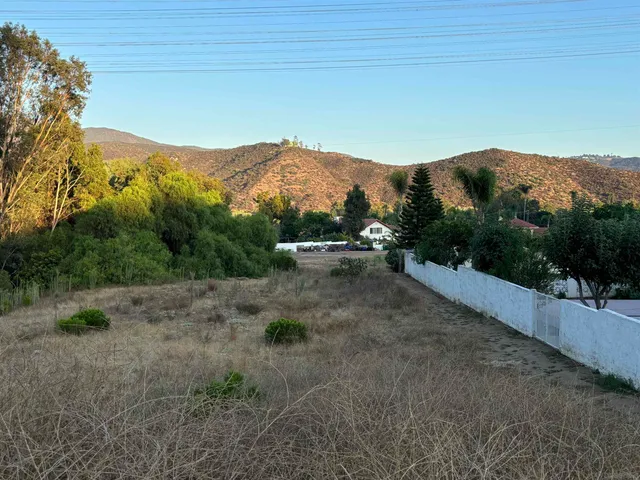 a view of a dry yard with mountains in the background