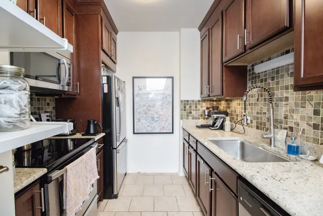 a kitchen with stainless steel appliances granite countertop a sink stove and refrigerator