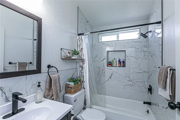 a bathroom with a bathtub shower sink vanity and toilet