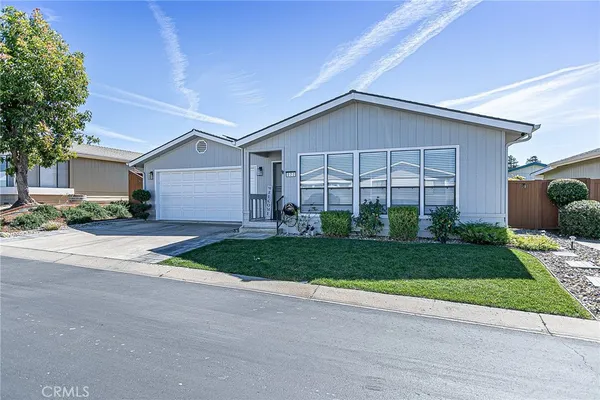 a view of a house with a yard and large tree