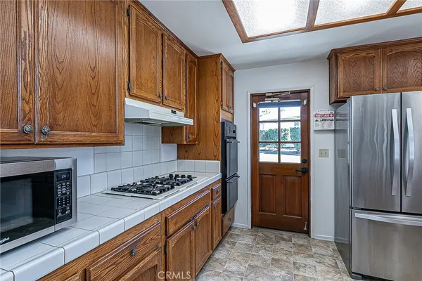 a kitchen with stainless steel appliances granite countertop a refrigerator stove and cabinets