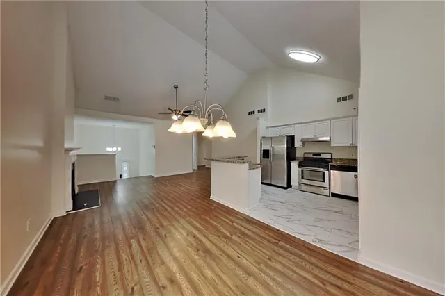 a view of a kitchen with a sink wooden cabinets and stainless steel appliances