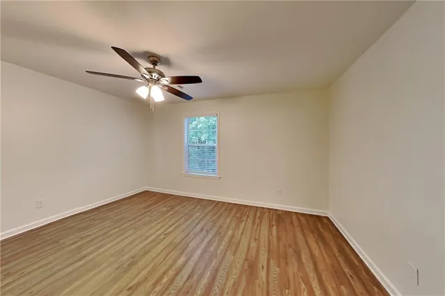 an empty room with a window and a ceiling fan