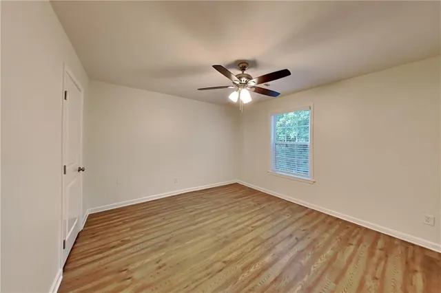 a view of an empty room with a window and a chandelier