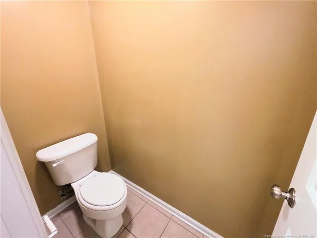 a white toilet sitting next to a white wall