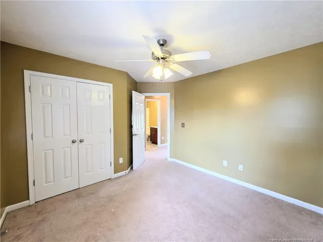 an empty room with a ceiling fan and a window