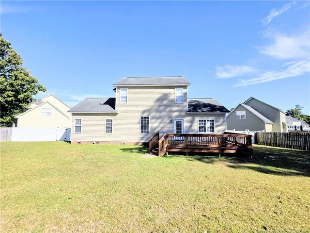 a front view of a house with a yard covered with snow and trees