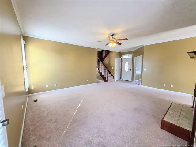a furnished livingroom with a ceiling fan