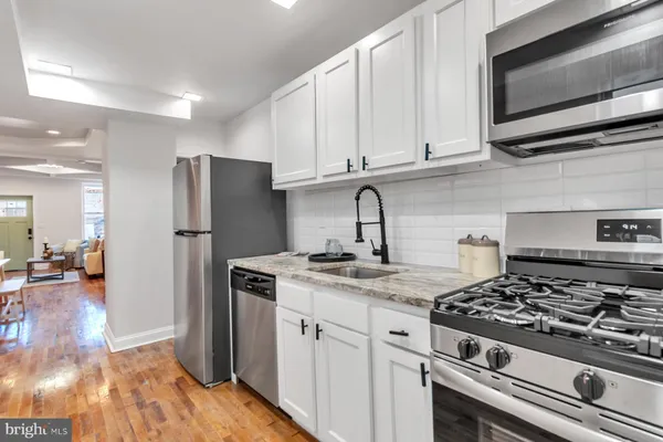 a kitchen with stainless steel appliances granite countertop a stove a refrigerator and a microwave