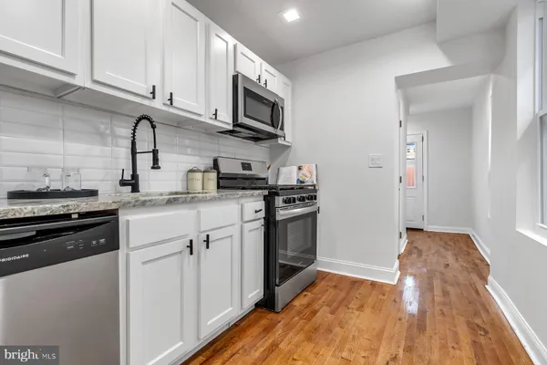 a kitchen with stainless steel appliances granite countertop a stove and a refrigerator