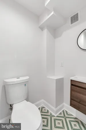 a white toilet sitting next to a bathroom sink