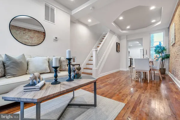 a living room with furniture and a wooden floor