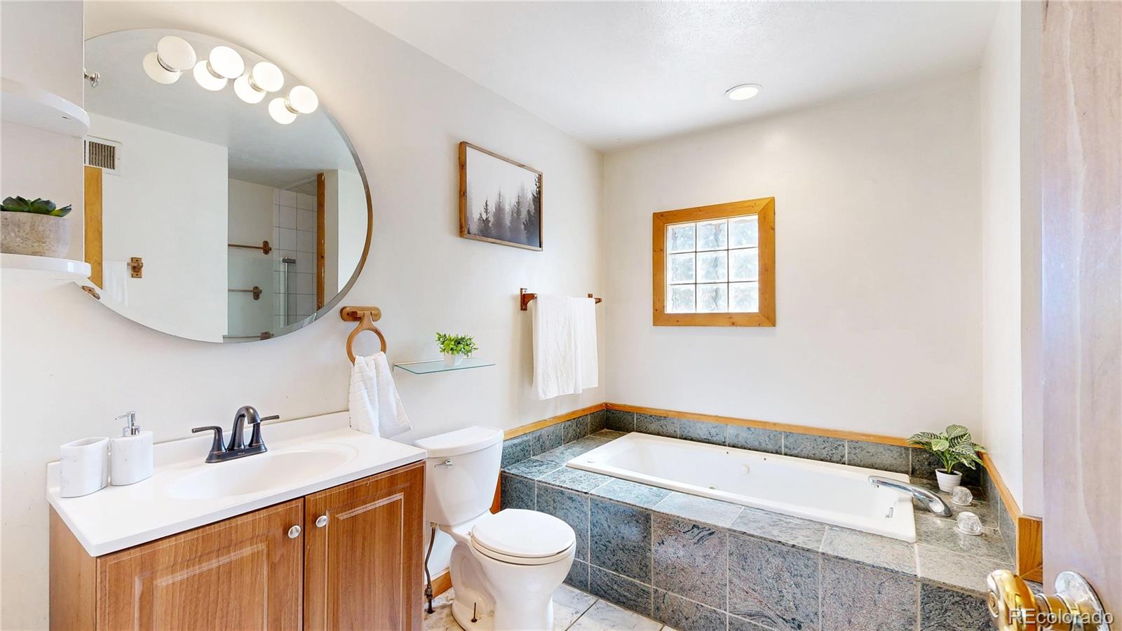 60 Ball Road Bailey, CO 80421 - Photo 14 of 37 a bathroom with a sink toilet mirror and vanity