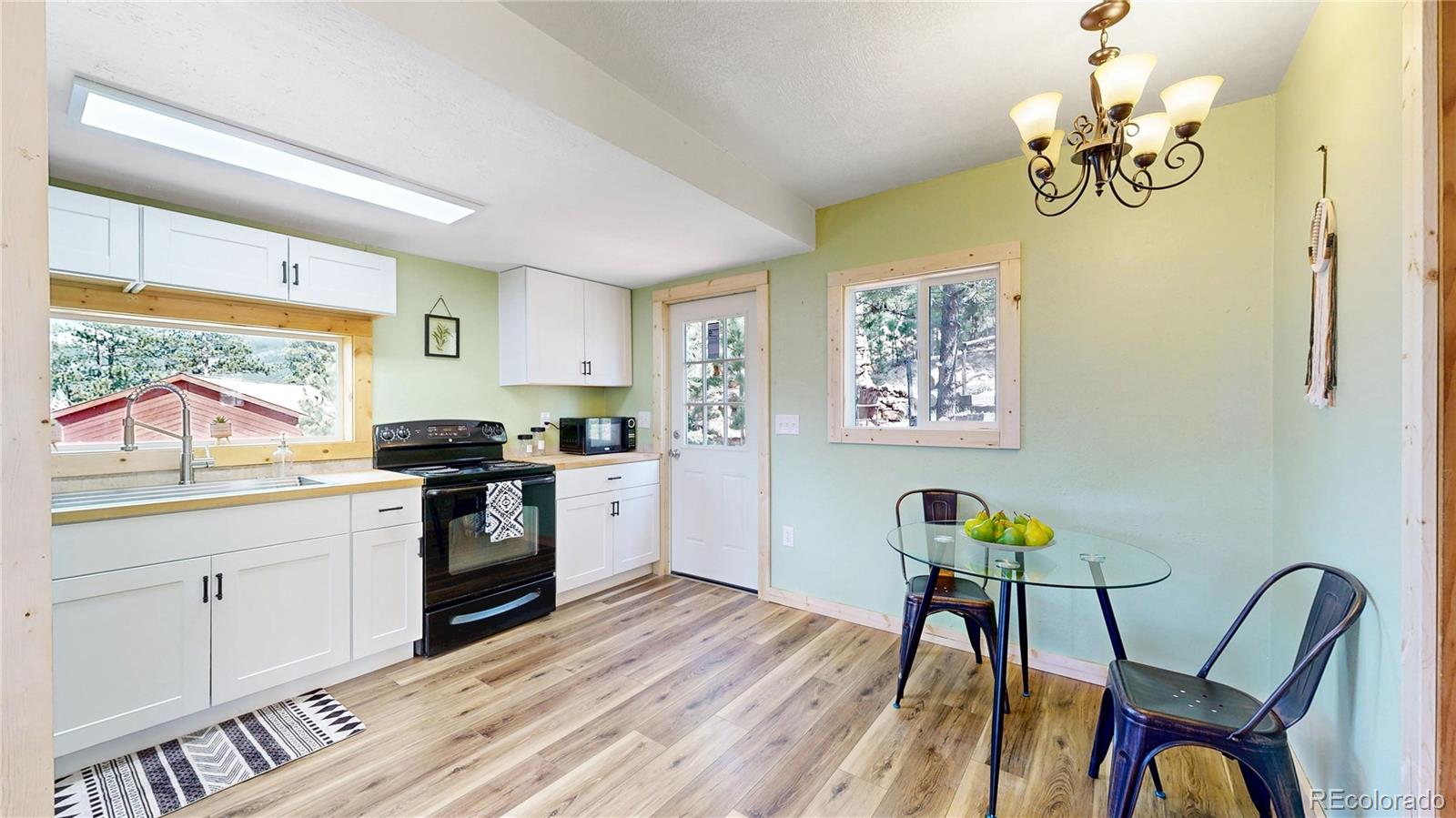 60 Ball Road Bailey, CO 80421 - Photo 4 of 37 a kitchen with stainless steel appliances granite countertop a stove a sink dishwasher and a dining table with wooden floor