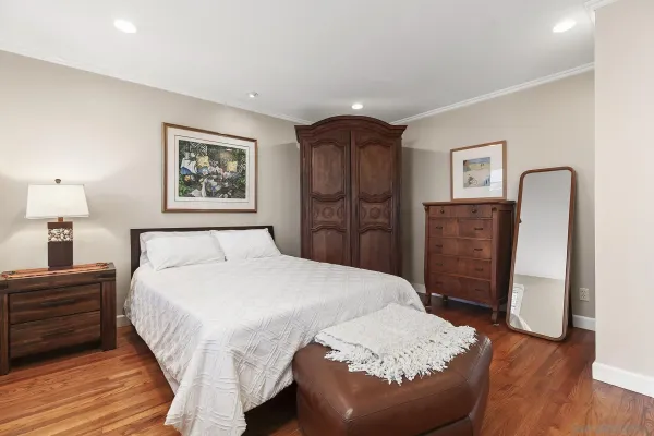 a spacious bedroom with a bed and a dresser