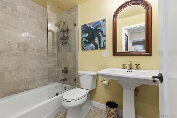 a bathroom with a sink a mirror a toilet and a bathtub