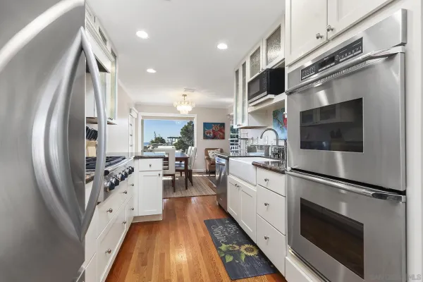 a kitchen with stainless steel appliances a stove a sink and a refrigerator