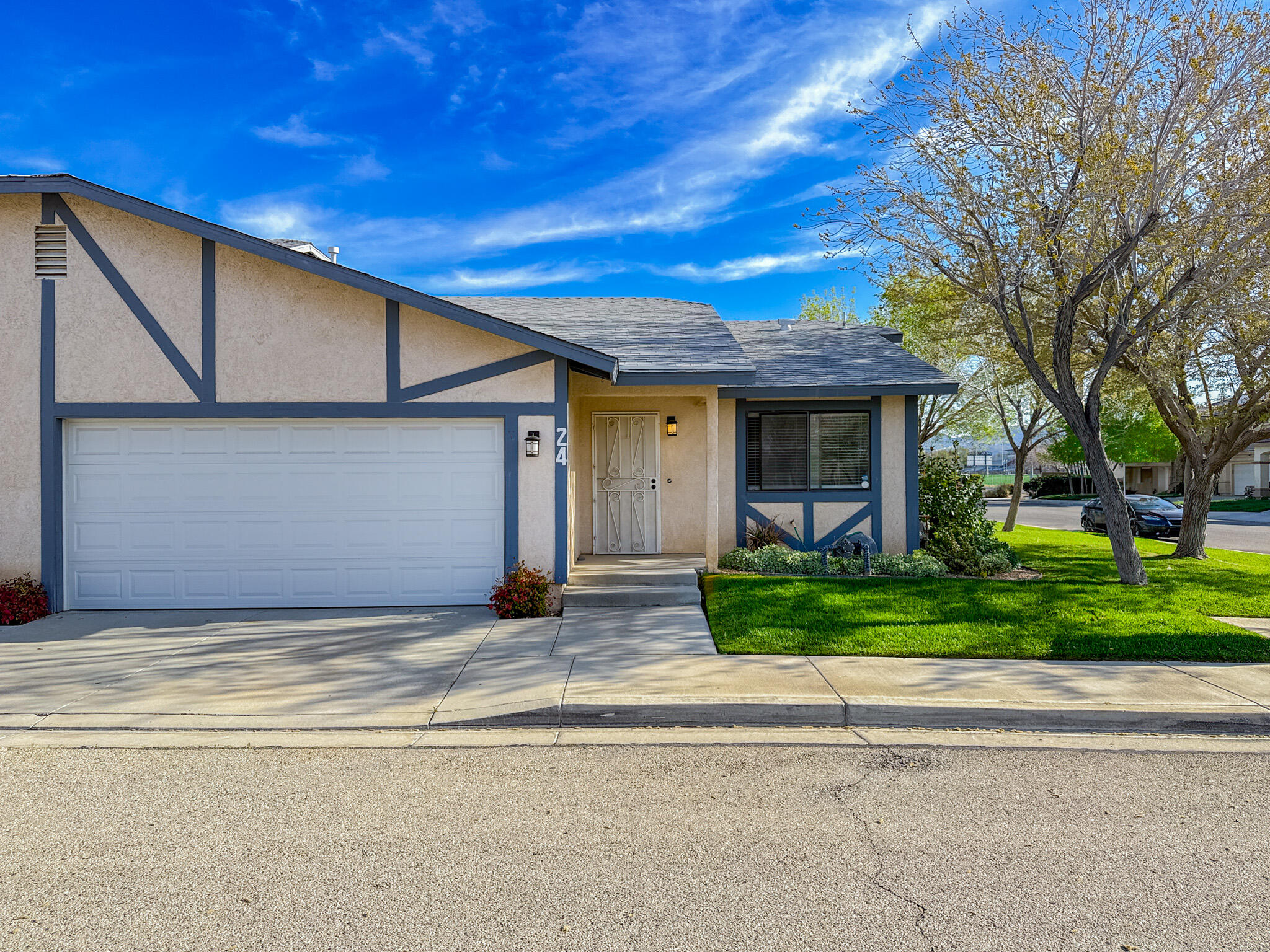 43840 Bobby Jones Drive, Unit 24 Lancaster, CA 93536 - Photo 1 of 29 a view of a house with a small yard plants and large tree
