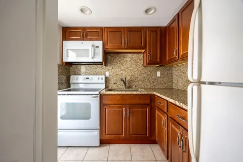 a kitchen with stainless steel appliances granite countertop a sink and a stove top oven