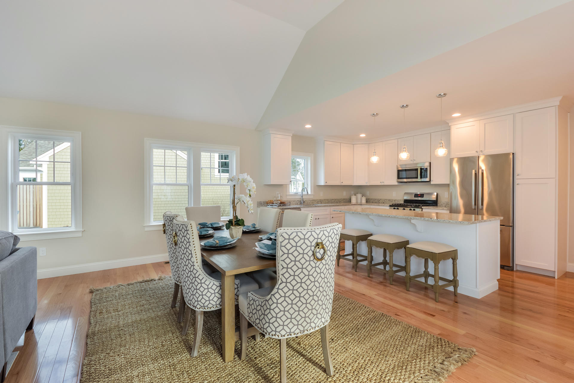 56 Cobblestone Circle Mashpee, MA 02649 - Photo 3 of 33 a dining room with stainless steel appliances kitchen island granite countertop a dining table chairs and a refrigerator