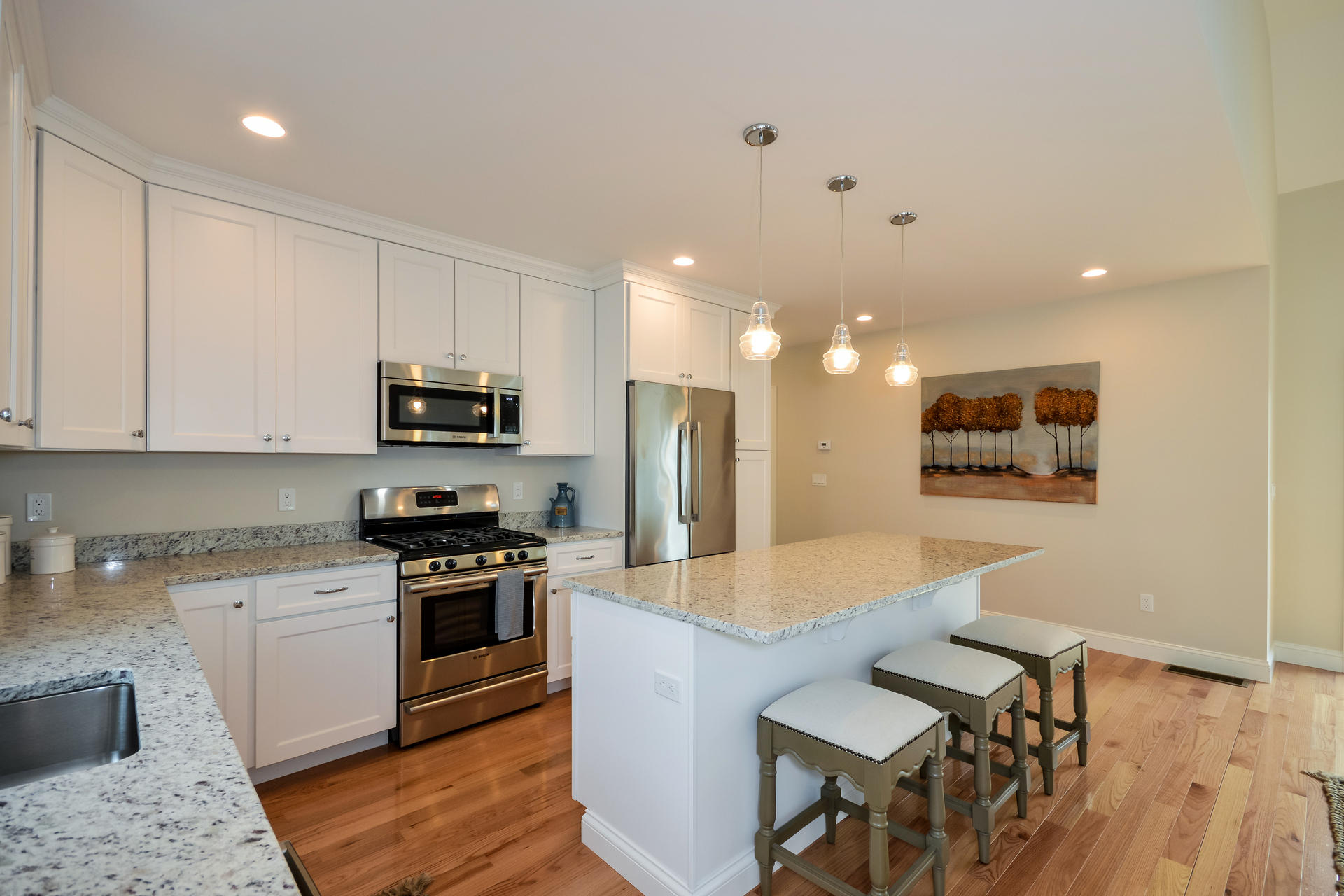 56 Cobblestone Circle Mashpee, MA 02649 - Photo 8 of 33 a large kitchen with stainless steel appliances kitchen island granite countertop a stove a sink a refrigerator and white cabinets with wooden floor