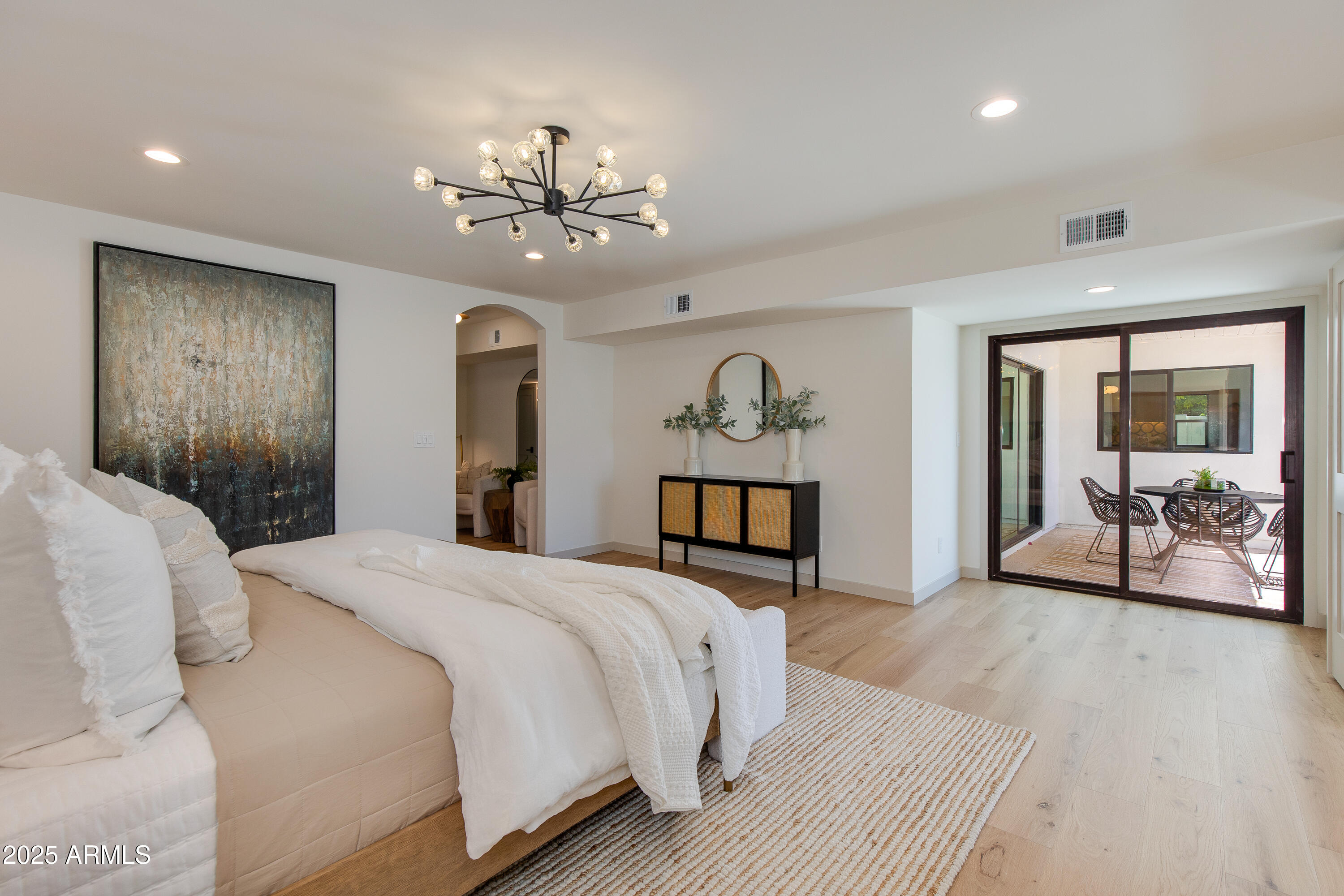 7328 East Laredo Lane Scottsdale, AZ 85250 - Photo 14 of 27 a spacious bedroom with a large bed and a chandelier