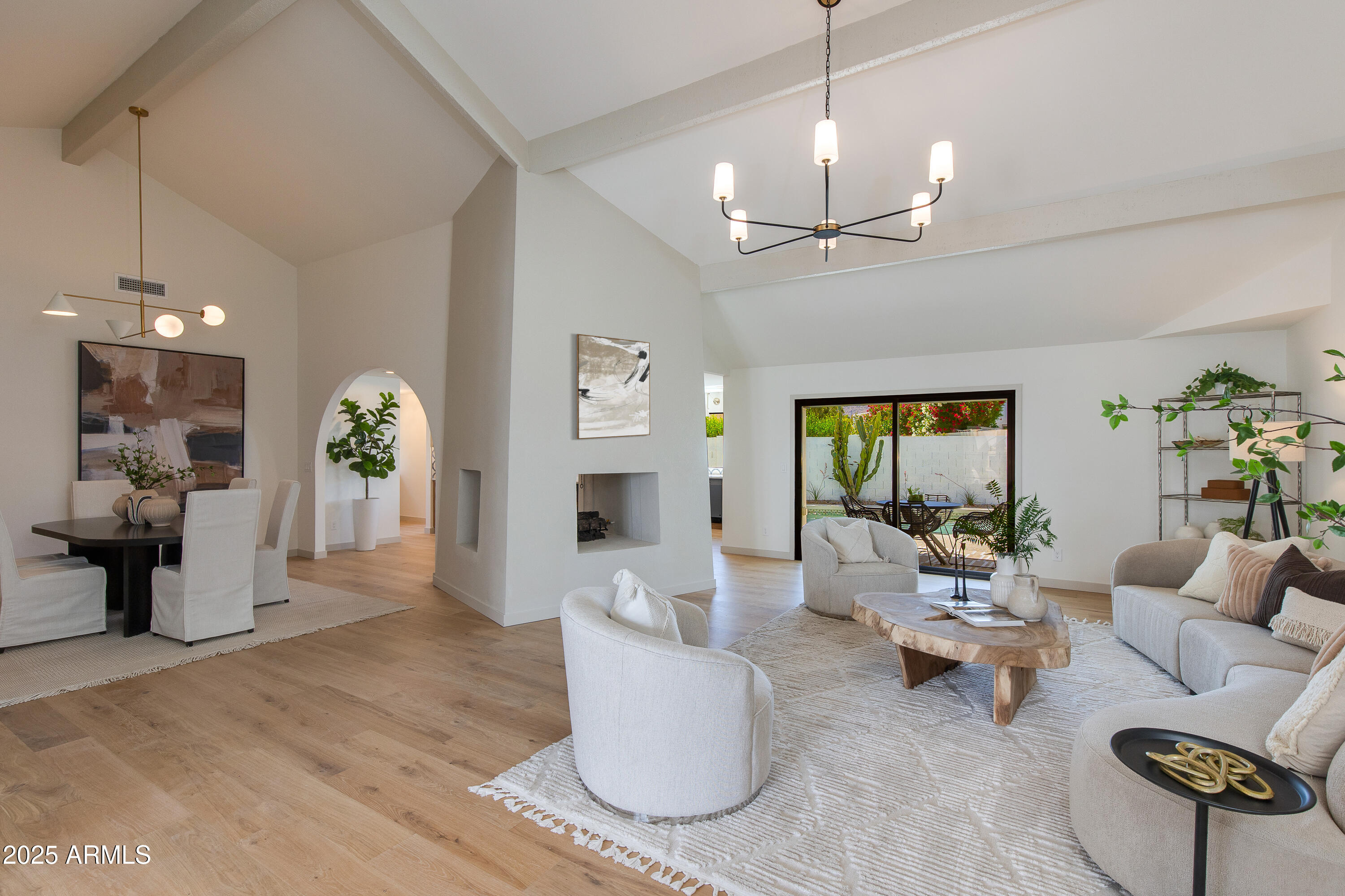 7328 East Laredo Lane Scottsdale, AZ 85250 - Photo 2 of 27 a living room with furniture a chandelier and a fireplace