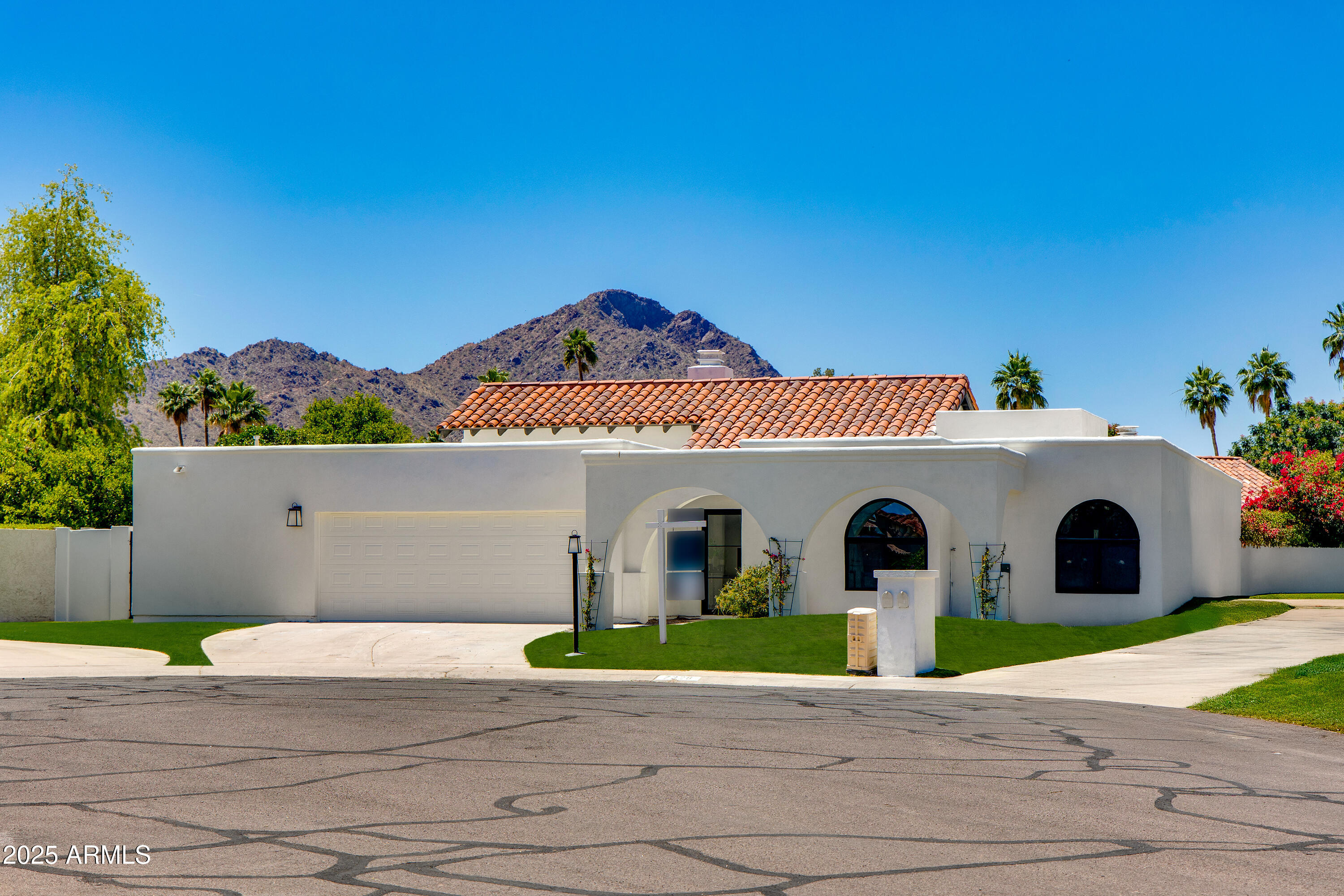 7328 East Laredo Lane Scottsdale, AZ 85250 - Photo 4 of 27 a view of a white house with a yard and table and chairs under an umbrella