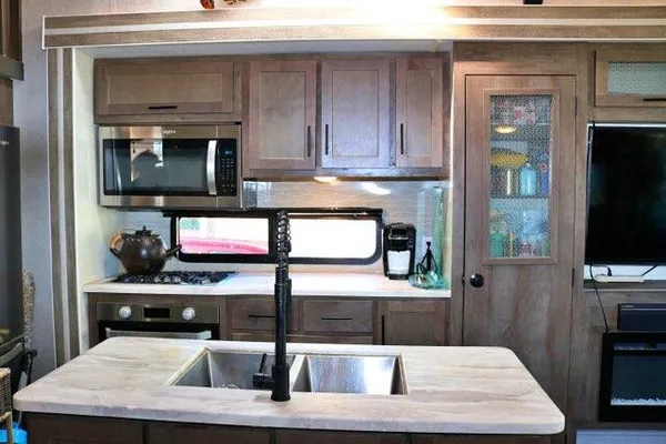 a kitchen with stainless steel appliances wooden cabinets a stove and a sink