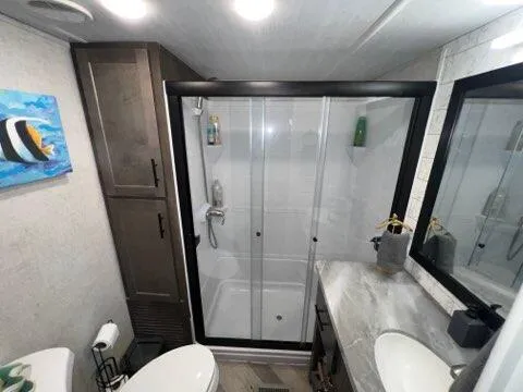 a bathroom with a sink toilet and shower