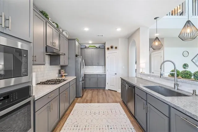 a kitchen with stainless steel appliances a sink stove and cabinets