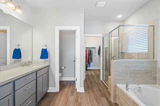 a bathroom with a granite countertop sink a mirror a vanity and bathtub