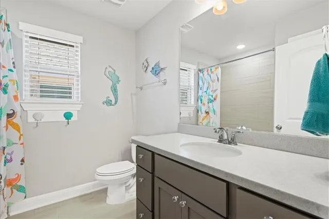 a bathroom with a sink a toilet and shower curtain